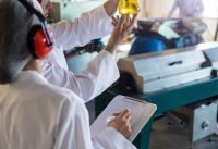 Technicians examining olive oil in factory